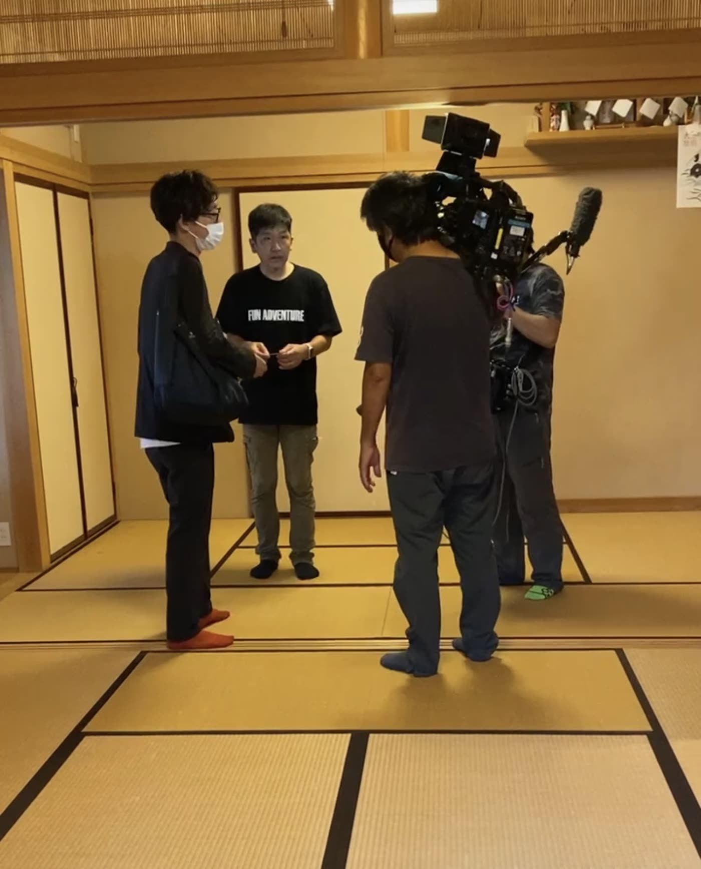 和室でNHKのディレクターの質問に答えるひでさん